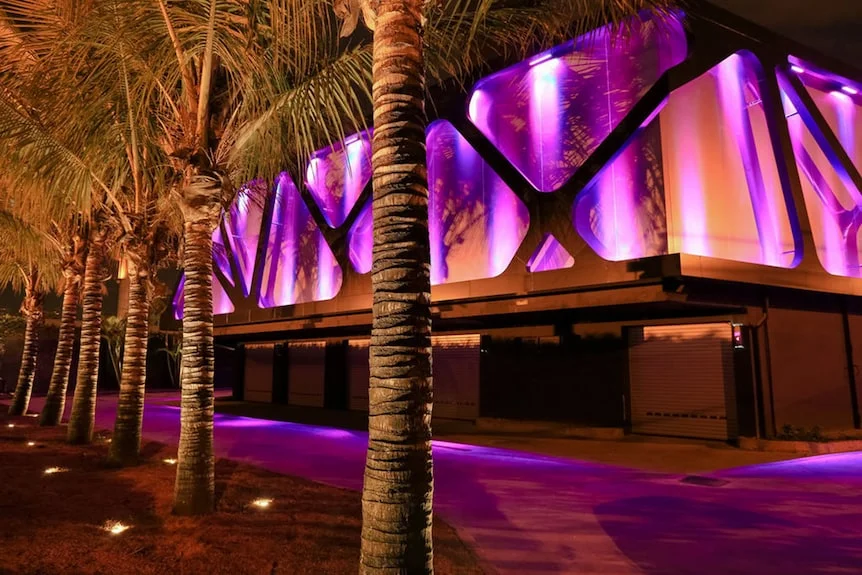 Fachada Lush Ipiranga iluminada em tons de púrpura e âmbar